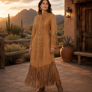 May include: A tan suede long coat featuring a high collar, a full-length front button closure, and vertical braided leather detailing along the bodice. The sleeves and hem are adorned with long, flowing fringe, and the cuffs feature turquoise accents.