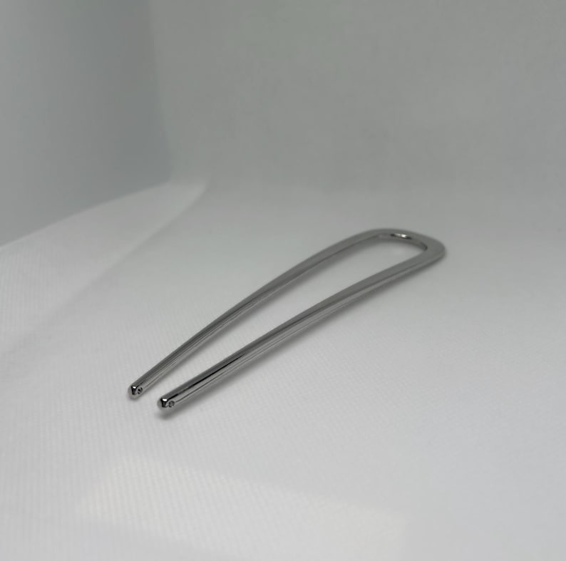 Peut inclure: Une &eacute;pingle &agrave; cheveux argent&eacute;e en forme de U. L'&eacute;pingle a une finition lisse et polie avec des extr&eacute;mit&eacute;s arrondies. L'accessoire pour cheveux est con&ccedil;u pour maintenir les cheveux en place.