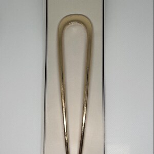 Peut inclure: &Eacute;pingle &agrave; cheveux fran&ccedil;aise dor&eacute;e, en forme de U. L'&eacute;pingle est pr&eacute;sent&eacute;e sur une carte cr&egrave;me avec le texte "PINNY THINGS" et "French Hair Pins" en noir. L'&eacute;pingle mesure environ 15 cm de long.