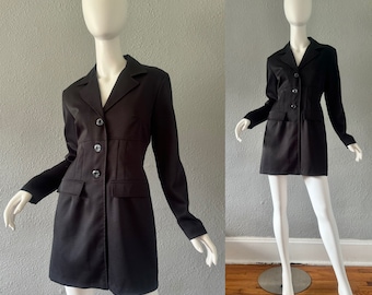 May include: A black blazer dress with a fitted waist and a button-up front. The dress has long sleeves and a collar.