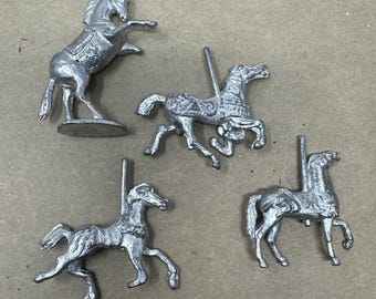 Konvolut von vier unbemalten Karussellpferden aus Blei. Zirkusfiguren aus Guss.