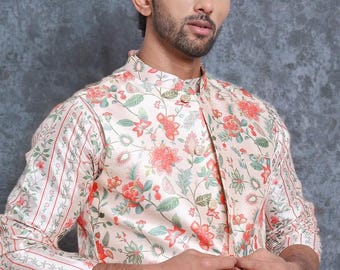 Può includere: Giacca color crema con stampa floreale e dettagli rossi e verdi. La giacca ha un colletto alla coreana ed è abbottonata. Le maniche hanno un design a righe con accenti floreali. Parte di una collezione di abbigliamento formale.