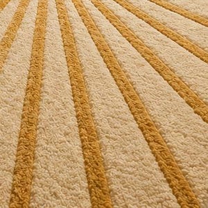 May include: A textured area rug featuring a repeating pattern of alternating wide cream-colored stripes and narrower mustard yellow stripes. The surface has a thick, tufted pile construction that creates a soft, raised appearance across the entire rug.