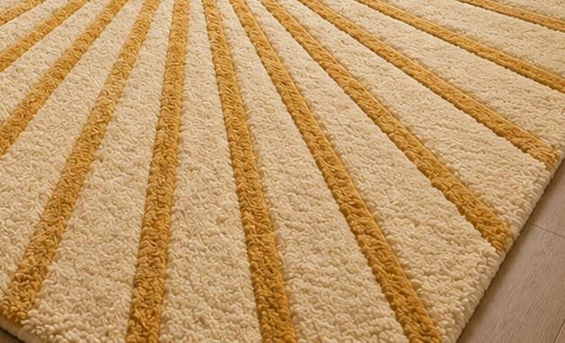 May include: A textured area rug featuring a repeating pattern of alternating wide cream-colored stripes and narrower mustard yellow stripes. The surface has a thick, tufted pile construction that creates a soft, raised appearance across the entire rug.