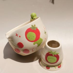 May include: A set of three ceramic nesting bowls in shades of blue, green, and white. The bowls feature a speckled glaze and a simple, modern design. The largest bowl measures approximately 6 inches in diameter.