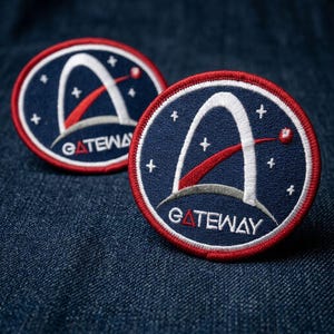 May include: Two embroidered patches with a navy blue background, a white arch, and a red accent. The patches have a red border and the word "GATEWAY" in white. The patches are circular and feature white stars.