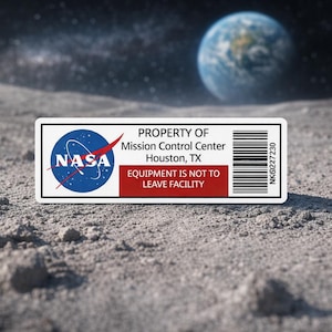 May include: A rectangular sticker with the NASA logo, text reading "PROPERTY OF Mission Control Center Houston, TX EQUIPMENT IS NOT TO LEAVE FACILITY," and a barcode. The sticker is set against a lunar surface with Earth in the background.