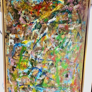 Könnte beinhalten: Abstrakte Malerei mit goldenem Rahmen. Das Kunstwerk zeigt eine strukturierte Oberfläche mit einer Mischung aus Farben, darunter Braun, Grün, Blau, Rosa, Gelb und Rot. Die sichtbaren Pinselstriche erzeugen eine dynamische und ausdrucksstarke Komposition.