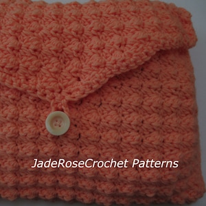 May include: A coral crocheted clutch with a button closure. The clutch has a textured design and a scalloped edge. The text "JadeRoseCrochet Patterns" is visible on the front of the clutch.