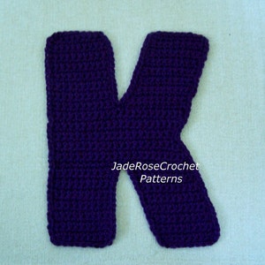 May include: A purple crocheted letter K. The letter is made with a single crochet stitch. The text "JadeRoseCrochet Patterns" is visible in the image.