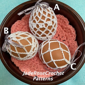May include: Three crocheted egg covers in a wooden bowl. The covers are white and have a geometric pattern. The bowl is on a pink crocheted doily. The text "JadeRoseCrochet Patterns" is visible at the bottom of the image.