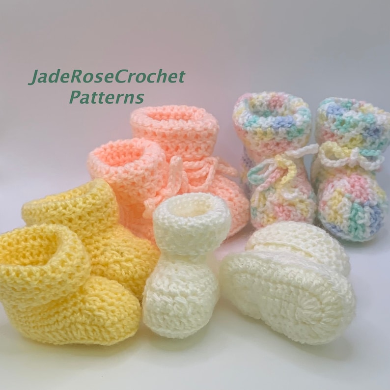 May include: Five pairs of crocheted baby booties in various colors, including yellow, pink, white, and pastel rainbow. The booties are made with a soft, textured yarn and have a simple, classic design.  JadeRoseCrochet Patterns.