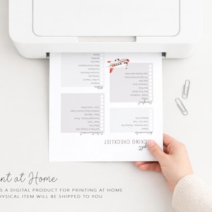 May include: A white sheet of paper with a printed packing checklist is emerging from a white printer. The checklist includes sections for documents, comfort, entertainment, and other items. The text "Print at Home" is visible.