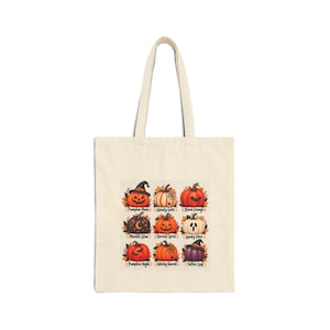 May include: A beige canvas tote bag featuring a grid of nine illustrated pumpkins. Each pumpkin has a unique design, including witch hats, ghosts, and bats, with text labels such as Pumpkin Moon, Ghouly Gold, Blood Orange, and Fallen Leaf.