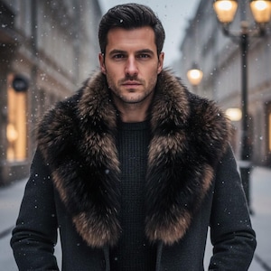 Puede incluir: Un hombre con un abrigo gris oscuro con un gran cuello de piel, de pie en una calle nevada. El cuello de piel es una mezcla de tonos marrones y negros, que contrastan con el abrigo y el suéter oscuros. El fondo muestra un paisaje urbano borroso.