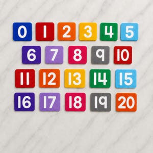 May include: A set of twenty square tiles arranged in four rows, each featuring a white number from 0 to 20. The tiles are coloured in various shades including blue, red, orange, yellow, green, purple, pink, and grey, with rounded corners.