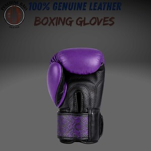 May include: A purple and black boxing glove made of genuine leather. The glove features a perforated black palm area and a purple wrist strap with a detailed pattern. Text at the top reads 100% GENUINE LEATHER BOXING GLOVES and PUNCHING BAGS HEAVEN.