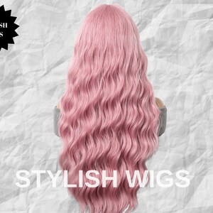 Puede incluir: Una peluca larga y ondulada de color rosa. La peluca presenta rizos sueltos y una l&iacute;nea de cabello natural. Las palabras "STYLISH WIGS" se muestran en texto blanco en la parte inferior de la imagen, con un logotipo de estrella negra en la parte superior.