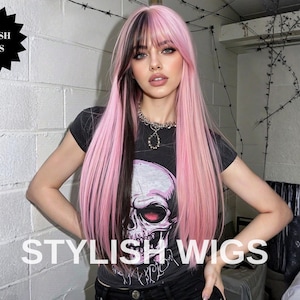 May include: A long, pink wig with a black streak, worn by a person. The wig has a fringe and is styled with long, straight layers. The person is wearing a black t-shirt with a skull graphic and the text "STYLISH WIGS".