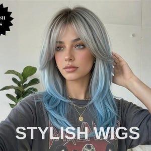 Puede incluir: Una persona con cabello largo y en capas en tonos plateados y azules. El cabello tiene flequillo y está peinado con una ligera onda. El texto "STYLISH WIGS" se muestra en la parte delantera de la camiseta gris oscuro.