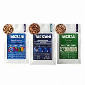 Könnte beinhalten: Drei weiße Kaffeetüten der Marke Tarzzani mit gerösteten Kaffeebohnen darauf. Die Tüten sind blau, dunkelblau und grün und tragen Aufschriften wie Opale Arlecchino, Spinello Cobalto und New Jade sowie Angaben zu Herkunft und Geschmack.