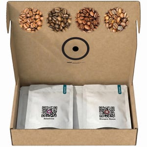 Könnte beinhalten: Ein Karton mit zwei weißen Kaffeetüten, beschriftet mit Ametrino und Diaspro Rosso, jeweils mit einem QR-Code. Der Innendeckel zeigt vier kreisförmige Ausschnitte, gefüllt mit verschiedenen gerösteten Kaffeebohnen und einem schwarzen Logo.