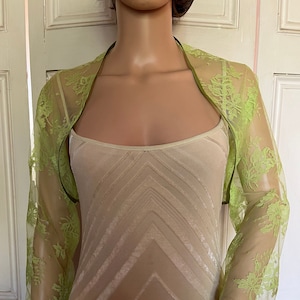 May include: A lime green lace bolero with a satin trim. The bolero is sheer and has a delicate floral pattern.
