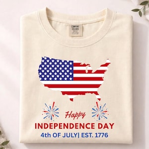 Peut inclure: T-shirt crème avec un motif de la carte des États-Unis aux couleurs du drapeau américain. Le t-shirt affiche le texte "Happy Independence Day" et "4th of July | Est. 1776" avec des illustrations de feux d'artifice.