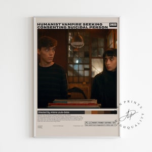 May include: A framed movie poster with the title "Humanist Vampire Seeking Consenting Suicidal Person" and the year 2023. The poster features two people and text at the bottom. The poster is in a neutral-toned frame.