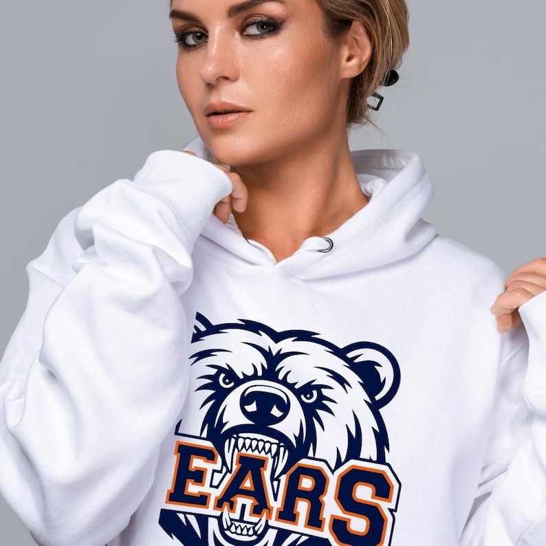May include: White hoodie with a navy blue and orange bear graphic. The word "BEARS" is printed in orange block letters below the bear illustration. The sweatshirt has a drawstring hood and long sleeves.