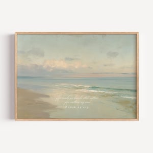 Könnte beinhalten: Ein gerahmter Druck mit einer ruhigen Strandszene in sanften Blau-, Grün- und Beigetönen. Das Kunstwerk zeigt ein ruhiges Meer, das auf einen sandigen Strand unter einem bewölkten Himmel trifft. Der Text lautet: „Er führt mich zu stillen Wassern; Er erquickt meine Seele. Psalm 23:2-3."