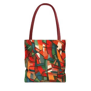 May include: A tote bag with an abstract design in red, orange, green, and blue. The bag has a burgundy handle. The bag's design is made up of geometric shapes and lines. It is designed for carrying items.