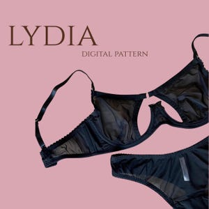 May include: A black underwire bra and matching underwear set featuring sheer mesh panels and adjustable straps. The text LYDIA DIGITAL PATTERN is displayed in brown lettering above the lingerie set against a solid light pink background.