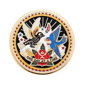 Peut inclure: Une broche ronde en métal doré représentant un oiseau squelette noir et un oiseau bleu face à face. En dessous se trouvent une rose rouge avec des feuilles vertes et une bannière avec le texte ONE DAY AT A TIME. La bordure a un motif de chaîne jaune et rouge.