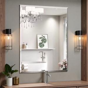 Peut inclure: Un miroir de salle de bain rectangulaire avec un bord biseauté, reflétant une salle de bain moderne. Le miroir est monté au-dessus d'un meuble-lavabo en bois avec un robinet argenté. Deux appliques noires et métalliques avec des ampoules Edison encadrent le miroir.