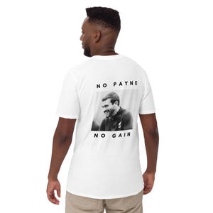 Puede incluir: Camiseta blanca con una imagen en blanco y negro de un hombre sonriendo y el texto "NO PAYNE NO GAIN". El gráfico es rectangular y está centrado en la parte posterior de la camiseta. La camiseta la lleva una persona.
