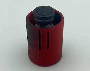 May include: A red cylindrical object with a black top, possibly a container or holder. The top has the letters "VIP" and other markings. The object is set against a plain white background.