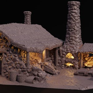 May include: A miniature stone cottage with a thatched roof, chimney, and a small outbuilding. The structure has a rustic appearance, with warm interior lighting visible through the windows and openings. Barrels and other details add to the miniature village scene.