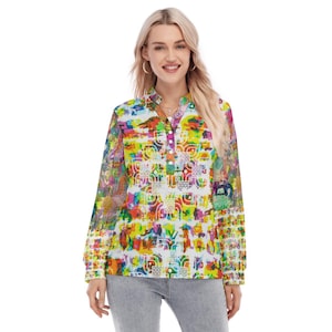 May include: A long-sleeved button-down shirt featuring a vibrant, multicolored abstract print with geometric patterns in shades of yellow, green, pink, and blue. The shirt has a mandarin collar, a partial button placket, and long sleeves.