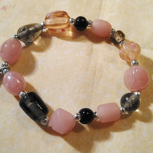 Mooie handgemaakte roze en zwart met hart en bloem charme glazen kraal stretch armband