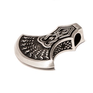 May include: A silver axe pendant with intricate knotwork and a detailed design. The axe head is curved and has a hole for a chain or cord.