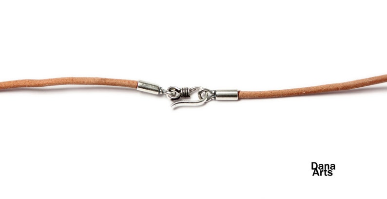 May include: A light brown leather cord necklace with silver metal clasps and a spring ring closure.