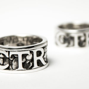 May include: Two silver rings with the word "CTR" embossed on them. The rings are textured and have a worn look.