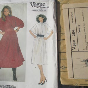 May include: Vogue Patterns sewing pattern for a dress, featuring two models wearing different styles of dresses. The pattern number is 2852. The text "Vogue Patterns" and "Paris Original" is printed on the pattern.