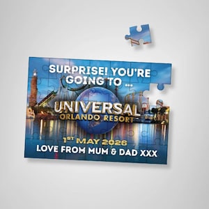 Può includere: Un puzzle parzialmente assemblato con il testo "SURPRISE! YOU'RE GOING TO... UNIVERSAL ORLANDO RESORT" e "1ST MAY 2026". Il puzzle presenta un'immagine di un parco a tema con cielo blu e acqua. È visibile anche il testo "LOVE FROM MUM & DAD XXX".