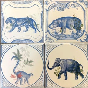 Puede incluir: Cuatro azulejos de cerámica azul y blanco con imágenes de animales. El azulejo superior izquierdo presenta un tigre, el azulejo superior derecho presenta un hipopótamo, el azulejo inferior izquierdo presenta un lémur y el azulejo inferior derecho presenta un elefante.