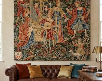 May include: A large rectangular wall tapestry featuring a detailed scene of figures in medieval attire gathered around a stone fountain in a lush garden. The design includes a central lute player, a pipe organ, a small lamb, and a heraldic shield.