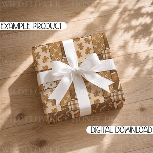 May include: A square gift box wrapped in brown and beige patterned paper featuring gingerbread men, candy canes, stars, and plaid squares, tied with a wide white satin ribbon bow. The text EXAMPLE PRODUCT and DIGITAL DOWNLOAD are visible.