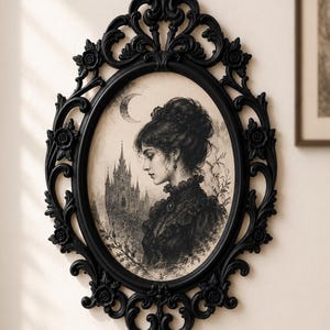 K&ouml;nnte beinhalten: Ein ovaler Wandspiegel mit einem schwarzen, verzierten Rahmen mit Blumenornamenten. Im Inneren des Rahmens befindet sich eine schwarz-wei&szlig;e Illustration einer Person mit Hochsteckfrisur vor einem Schloss unter einer Mondsichel.