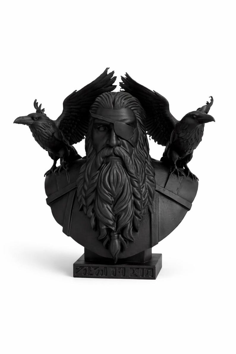May include: Black bust sculpture of a bearded man with an eye patch, flanked by two ravens with outstretched wings. The sculpture is on a rectangular base with engraved text. The bust is a decorative item.